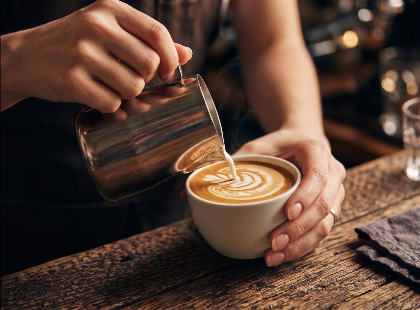 Barista preparando café detrás de la barra de la cafetería